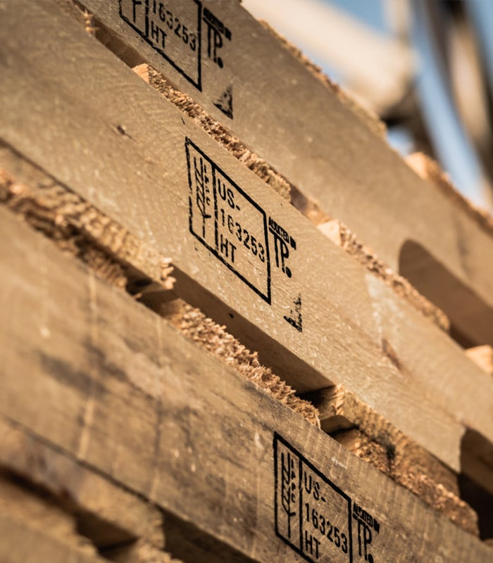 Close up of a few ISPM-15 Heat-Treatment certification stamps on wooden pallets