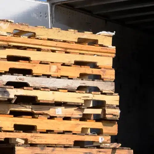 Stack of used pallets with used carboard and left-over shrink wrap