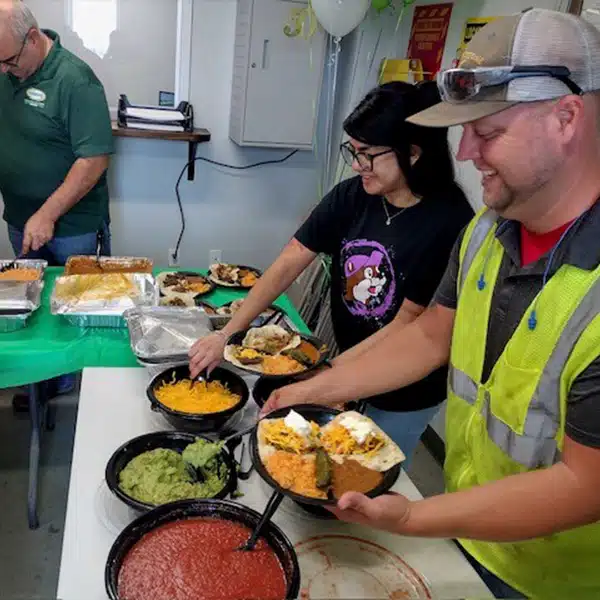 Employees smiling and grabbing food in lunch room