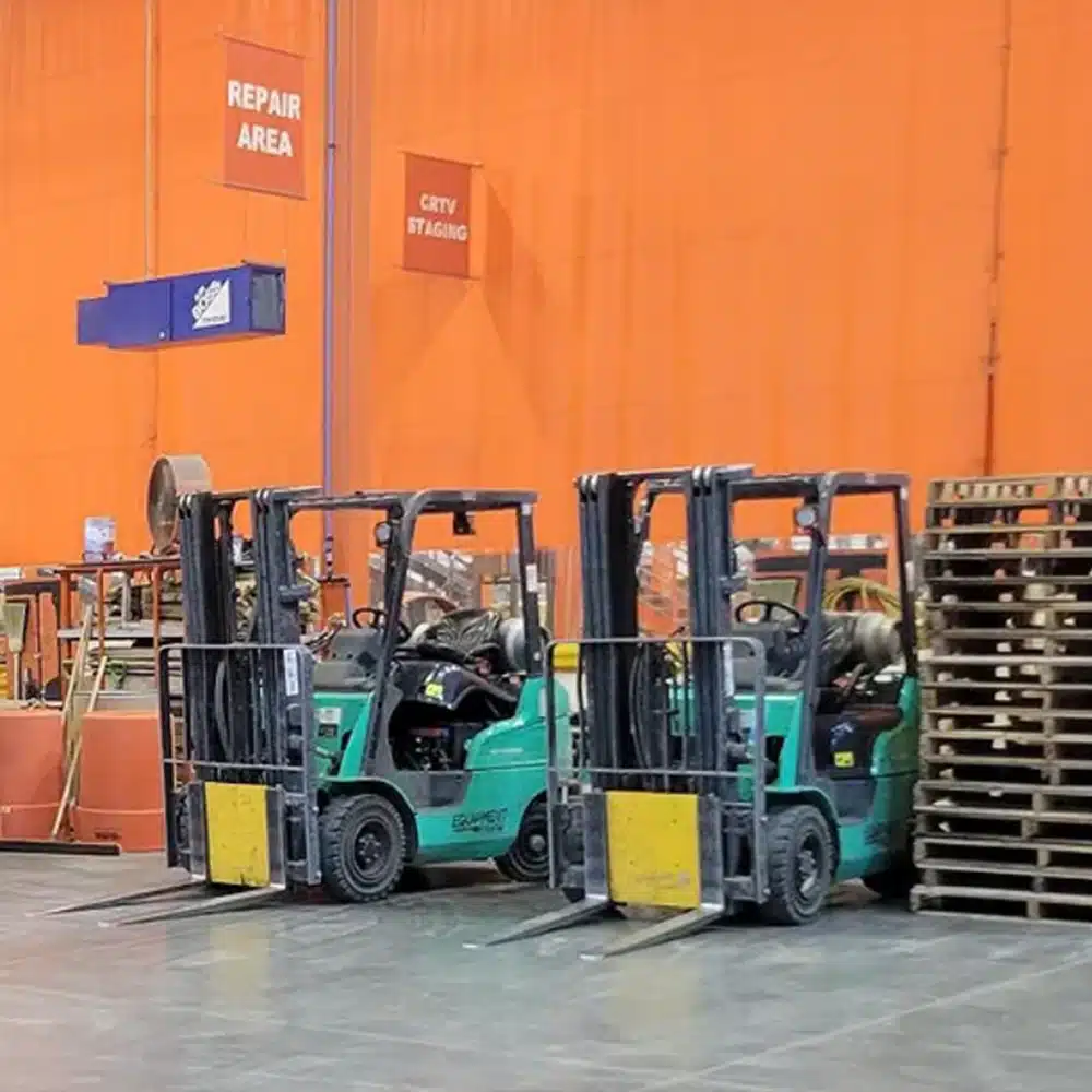 A row of forklifts with no operators neatly parked to one another