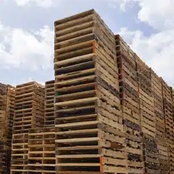 Stacks of used remanufactured pallets in a yard